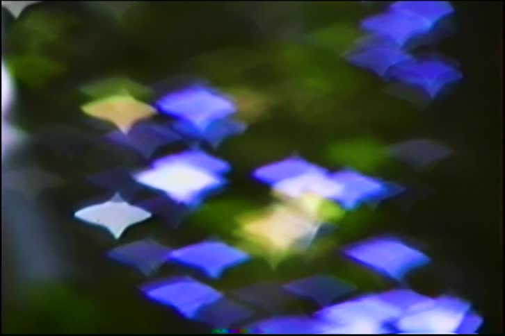 A dreamy, abstract background of shimmering star-shaped blue and green bokeh lights