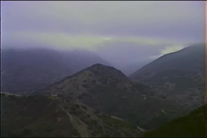 Vintage footage slowly zooms in on a misty and mysterious mountain landscape