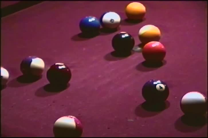Vintage close-up footage shows a pool player taking a shot on a purple felt table