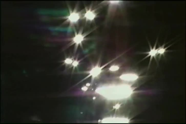 Abstract starburst lights shimmer and dance on the surface of dark water