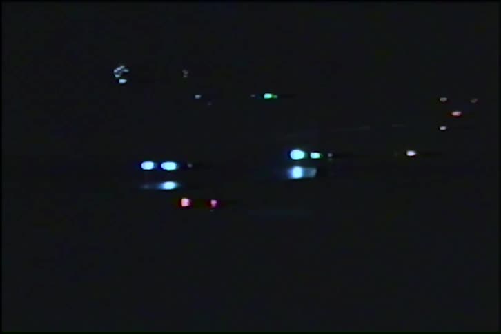 Abstract archival footage captures the blurry headlights and taillights of cars driving on a highway at night