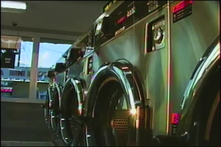 A slow, low-angle push-in shot reveals a row of vintage stainless steel washing machines in a deserted laundromat