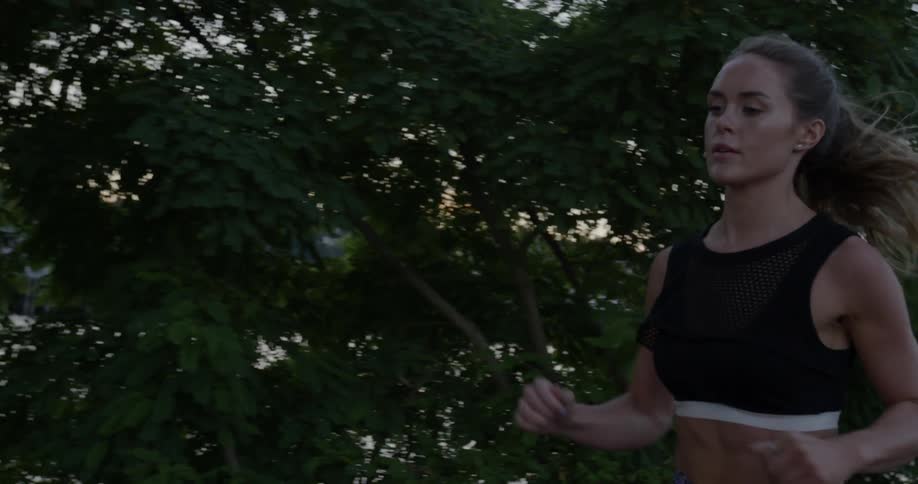 Woman jogging next to a lake in slow motion