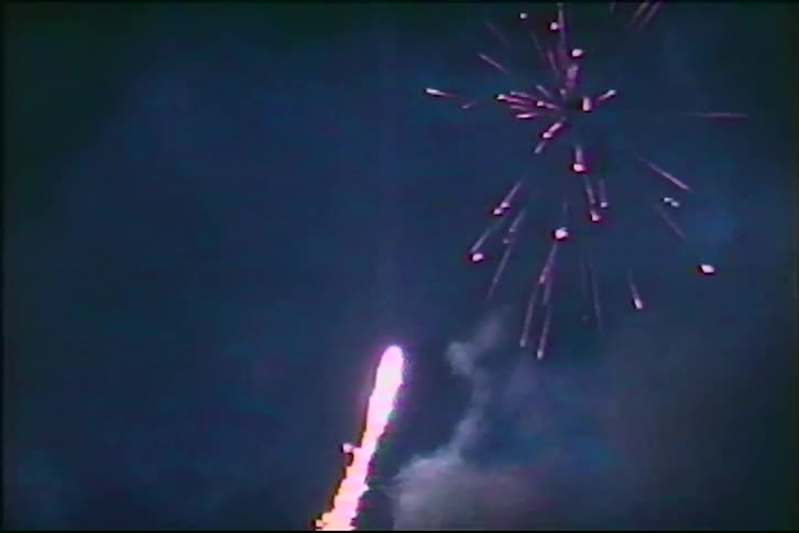 Old VHS footage captures a colorful fireworks display against the dark night sky