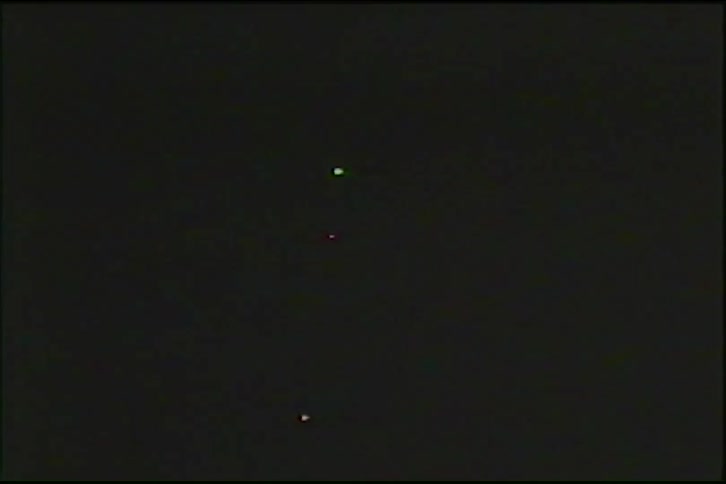 Vintage VHS footage shows a single purple firework exploding against the dark night sky