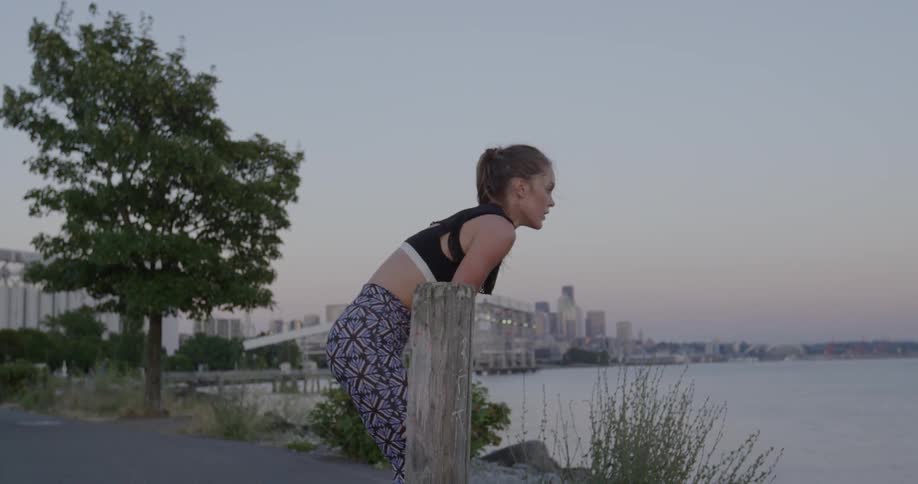 Woman leans over looking out at water