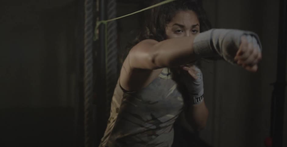 A female athlete is training using a rope line in a gym