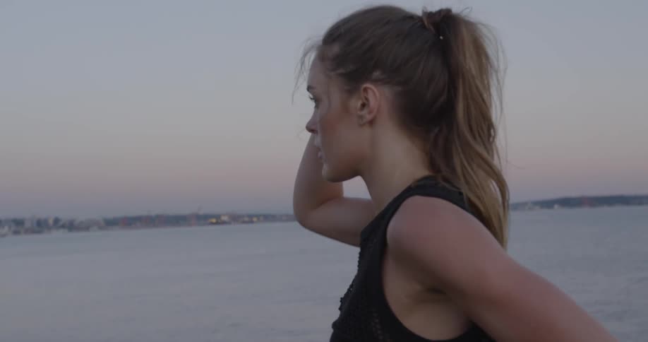 A woman looks around and touches her head