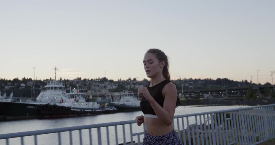 A woman is jogging outside near the pier