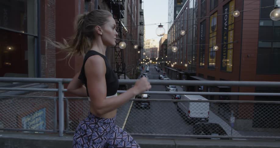 A woman jogs on a pathway in a warehouse district