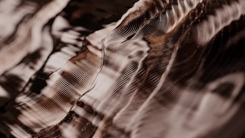 A mesmerizing macro view of a slowly flowing abstract substance with intricate metallic bronze textures and patterns