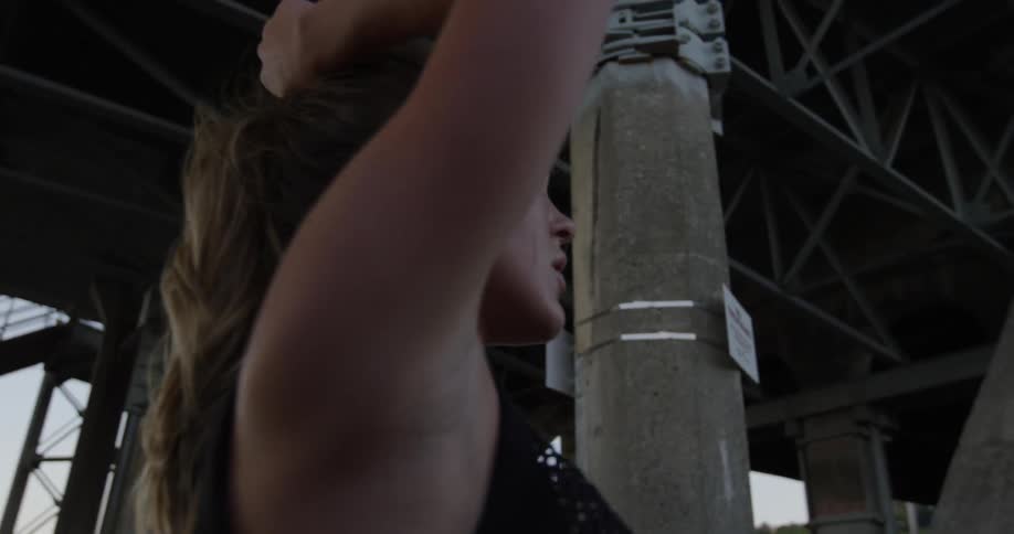 A woman has her hands above her head outside