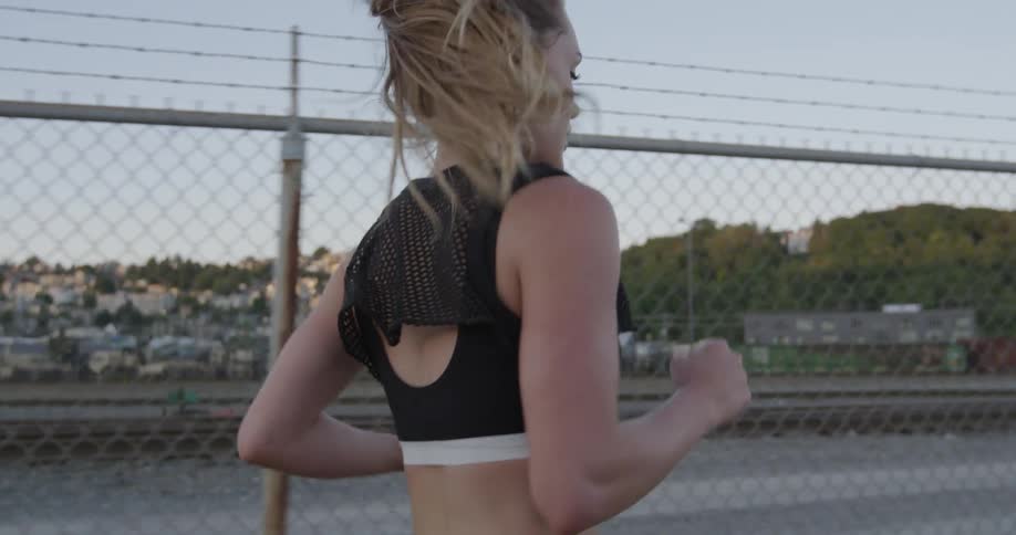 A woman is running past a fence