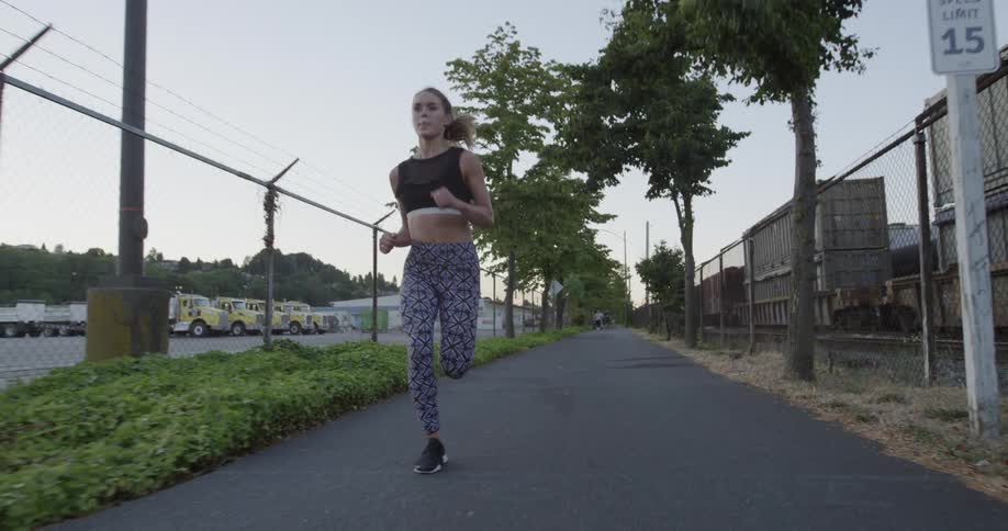 A woman jogs on a city sidewalk