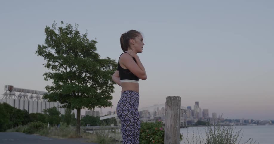 A woman stretches near a tree