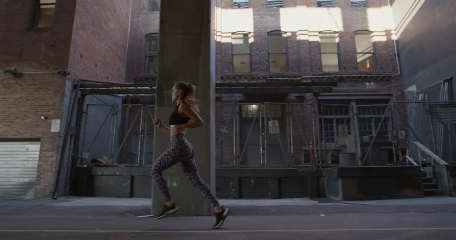 Woman jogging in an industrial part of a city
