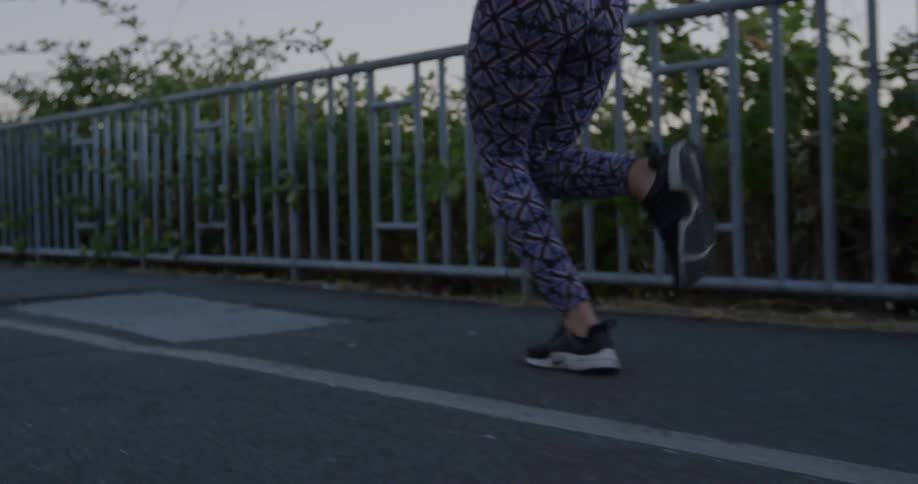 Woman jogs on a road at sunset
