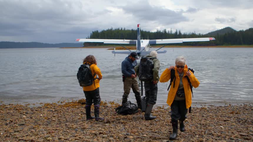 A group of adventurers are dropped off by a floatplane and watch it taxi away from a remote, rocky shore