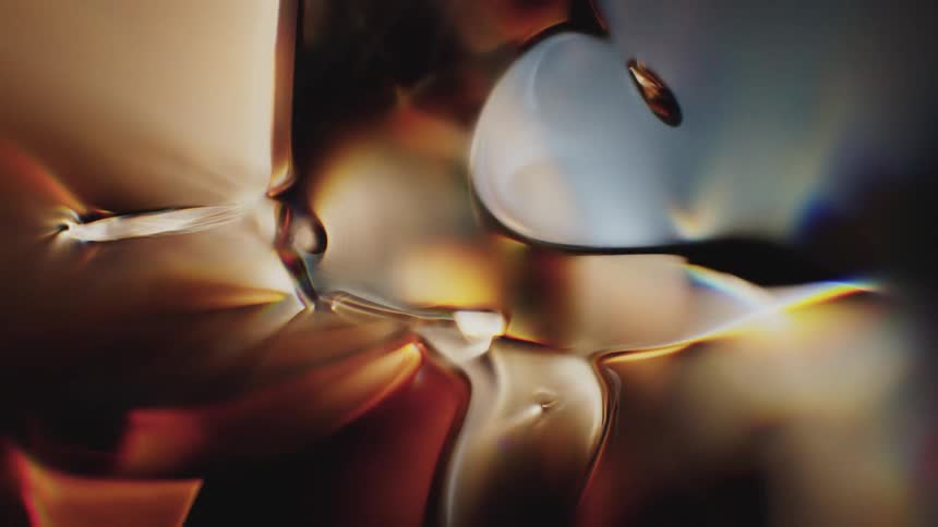 Warm amber and gold tones shift and blend in a mesmerizing, slow-motion abstract liquid animation