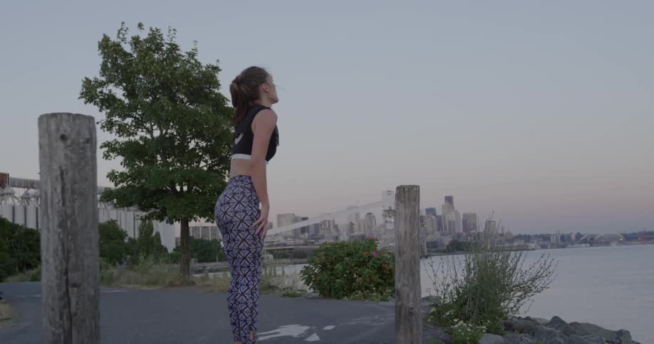 A woman leans over to catch her breath in a city park