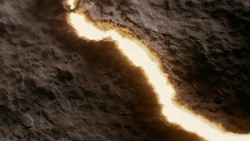A glowing, fiery line slowly burns a winding path across a dark, textured surface in a macro shot