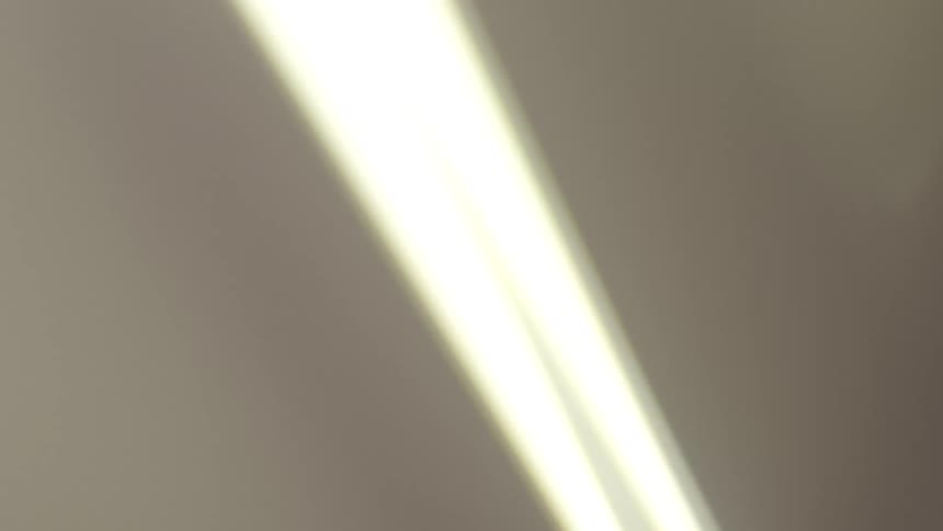 Dreamy and blurry low-angle view of a spinning ceiling fan creating a hazy and abstract visual