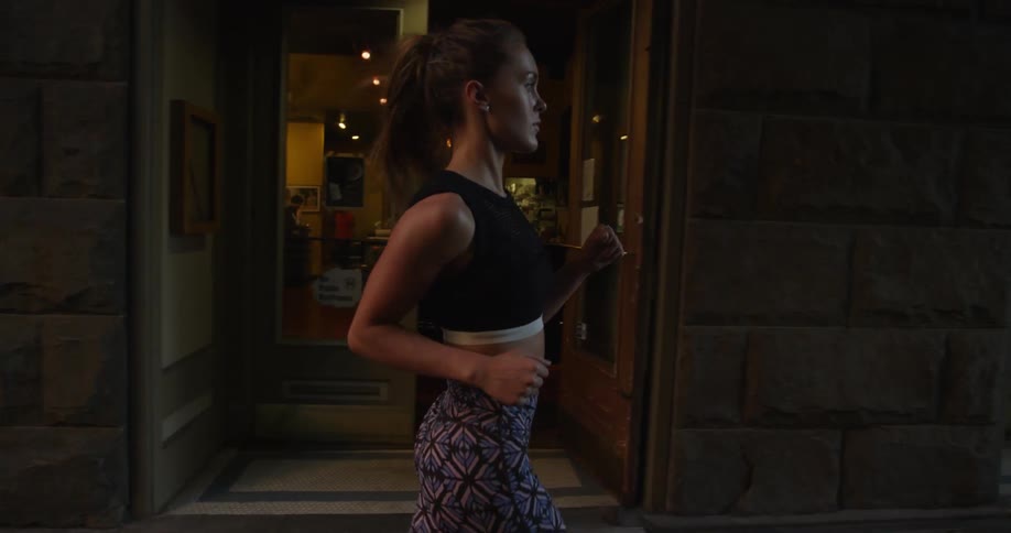 A female is jogging past some shops