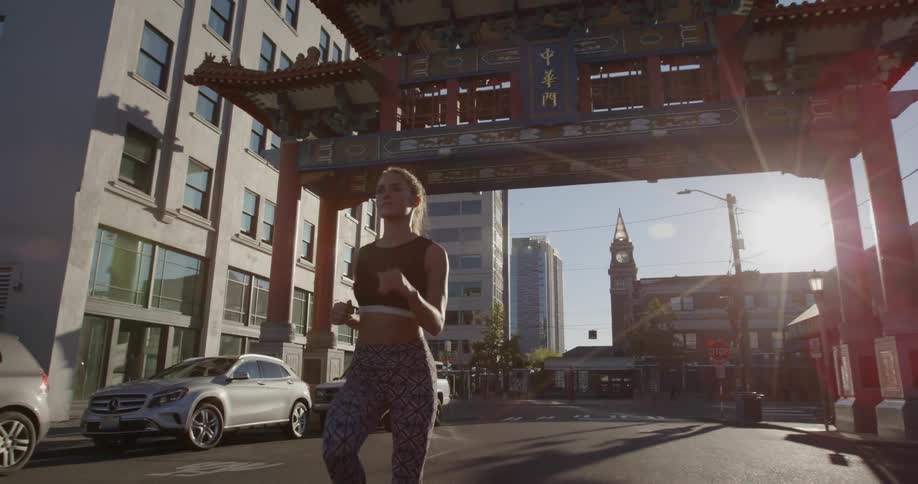 A woman is running outside on a sunny day