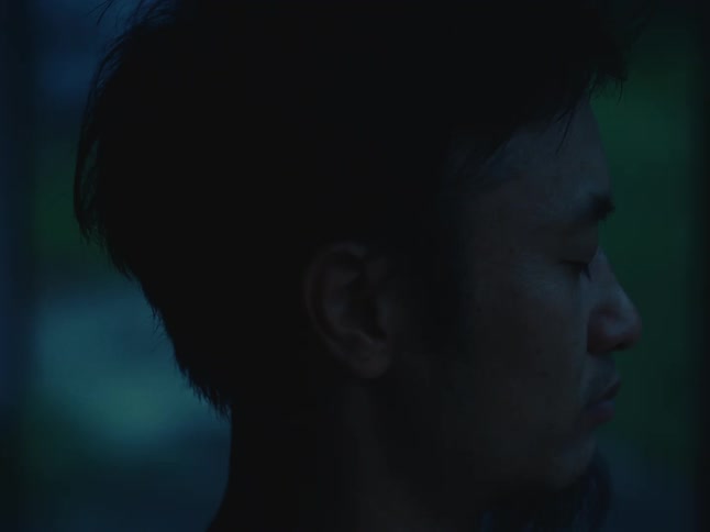 A close-up profile of a serene man with his eyes closed in quiet contemplation at dusk