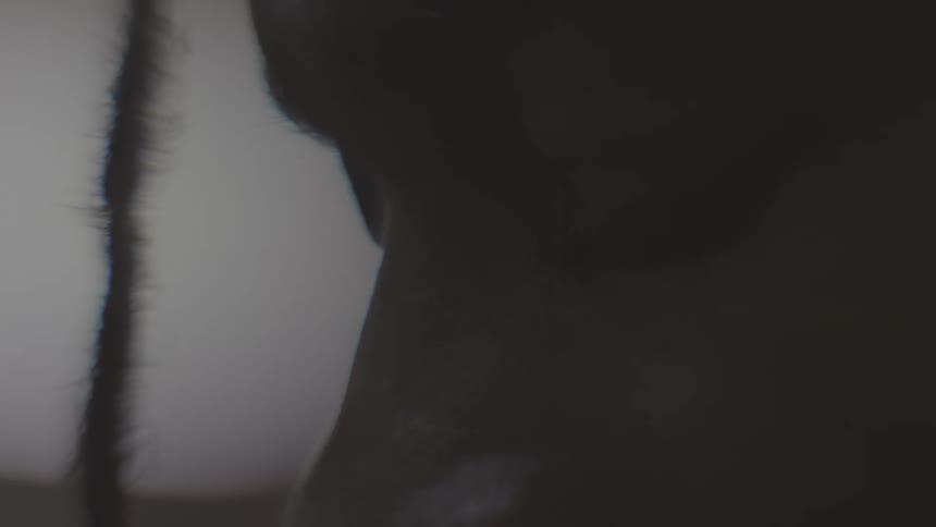 An intense and moody extreme close-up reveals the eye of a Black man with dreadlocks looking down