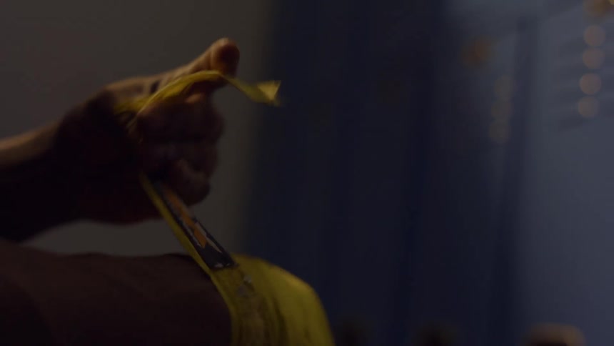 Close-up slow motion shot of a fighter meticulously wrapping their hands with yellow tape before a fight