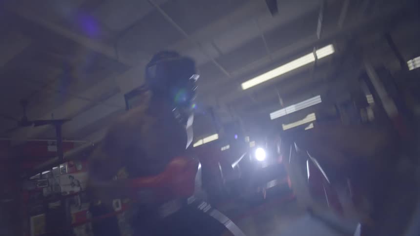 Dynamic point-of-view shot of two boxers sparring intensely inside a gritty, backlit boxing ring