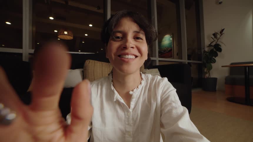 A woman has an emotional reaction from happy to sad to joyful during a point-of-view video call