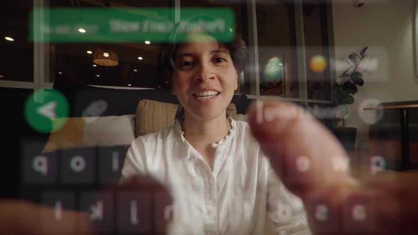 POV of someone typing a message on a transparent phone screen to a happy woman sitting on a couch