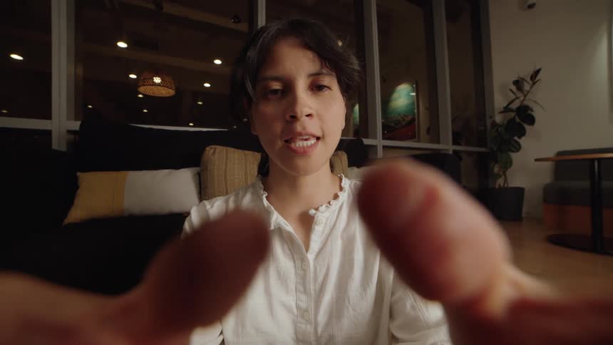 A woman's point-of-view as she talks to someone, with their fingers blurred in the foreground