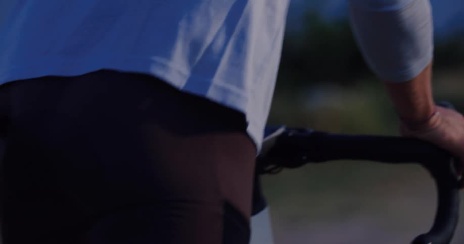 Slow motion detail shot of a cyclist's hand on the handlebars as they start their ride at dusk