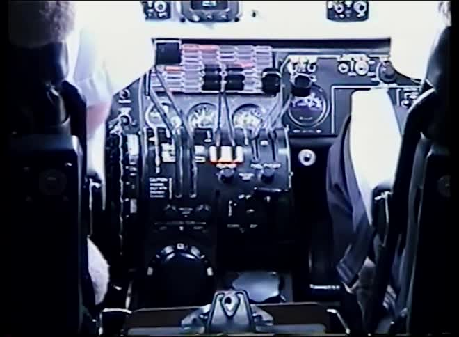 Vintage archival footage shows the complex instrument panel and throttle controls inside an airplane cockpit