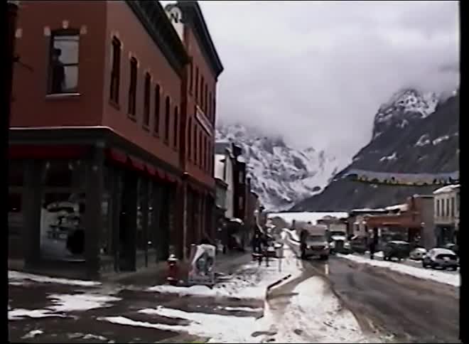 Panning shot of a historic, snow-covered mountain town street during a quiet winter day