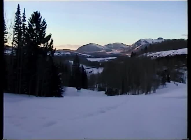 Vintage home movie captures a family's horse-drawn sleigh ride through a beautiful snowy mountain landscape at dusk