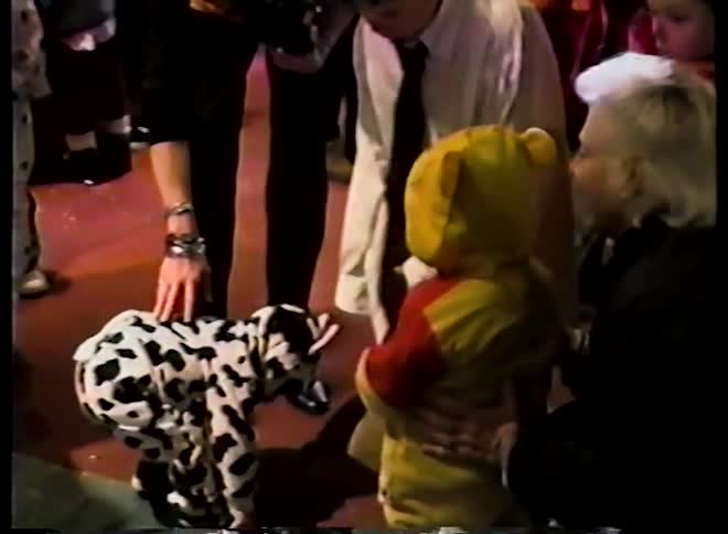 Vintage home video footage shows two toddlers in cow and Winnie the Pooh costumes at a Halloween party