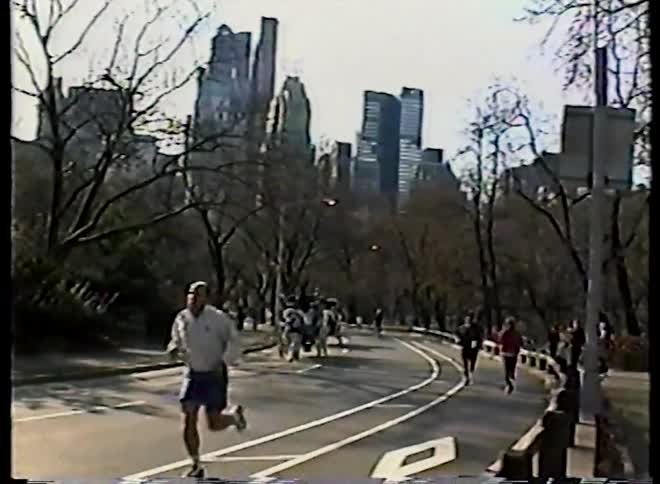 Archival footage shows joggers and a horse-drawn carriage in Central Park with the Manhattan skyline in the background