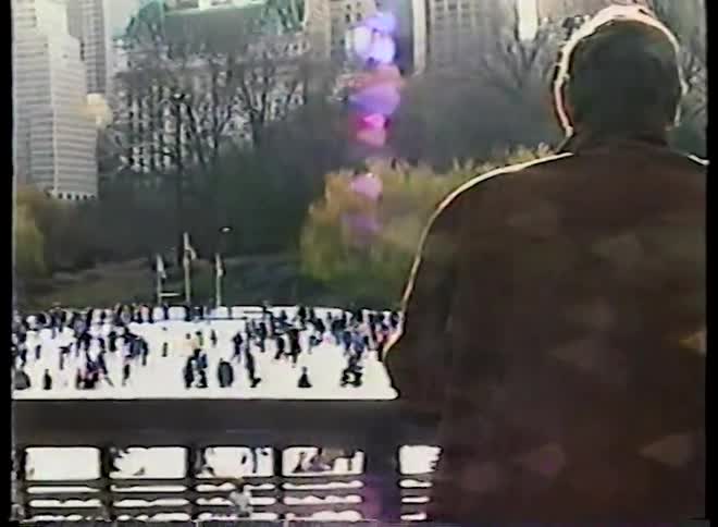 Vintage 1980s VHS footage captures a couple looking out over the bustling ice skating rink in New York City's Central Park