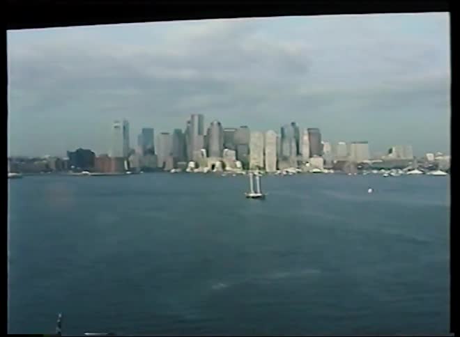 Vintage 1991 footage captures a slow pan across the harbor, revealing the iconic New York City skyline with the World Trade Center towers and boats on the water