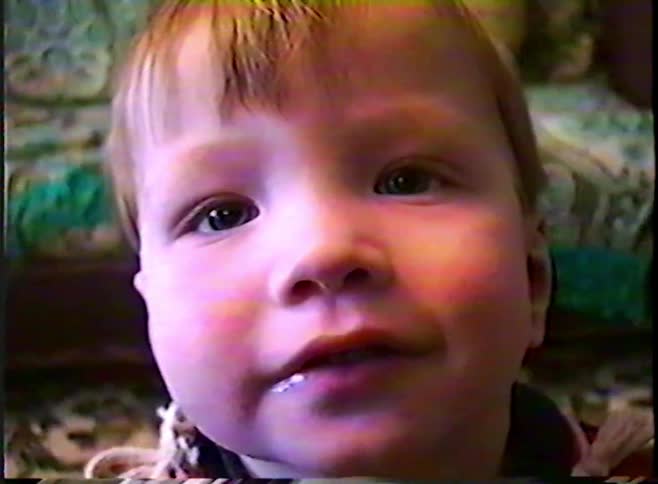 A close-up home video from the 1980s shows an adorable toddler smiling sweetly at the camera