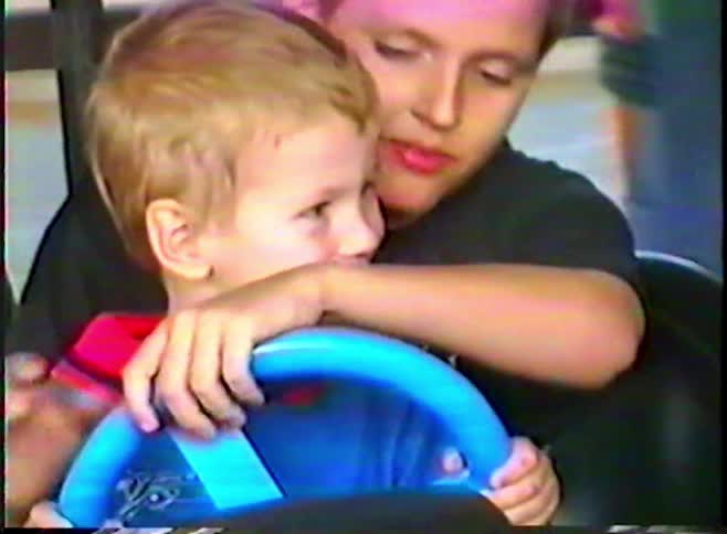 Close up of two young brothers having fun together in a bumper car at an amusement park
