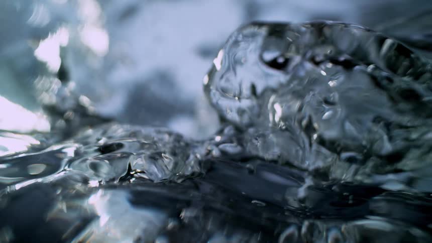 Extreme close-up footage captures the turbulent surface of boiling water in mesmerizing slow motion