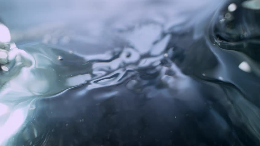 Mysterious dark water bubbles and creates a mesmerizing vortex in a slow-motion macro shot