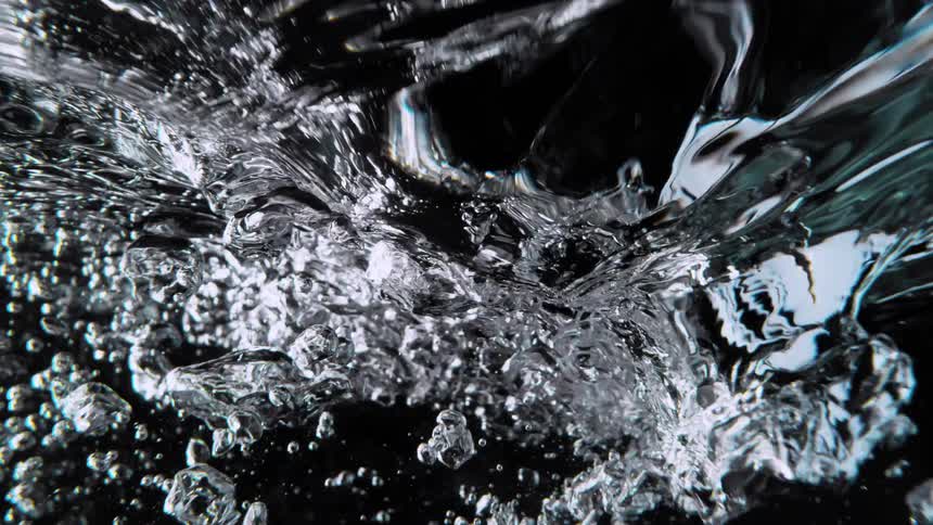 A super slow-motion close-up of turbulent water and air bubbles against a black background