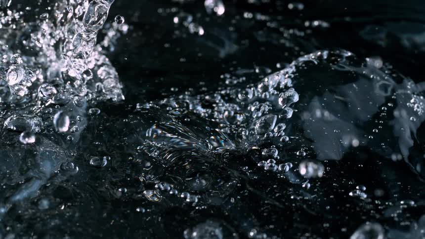An extreme closeup of churning water creating bubbles and splashes captured in super slow motion