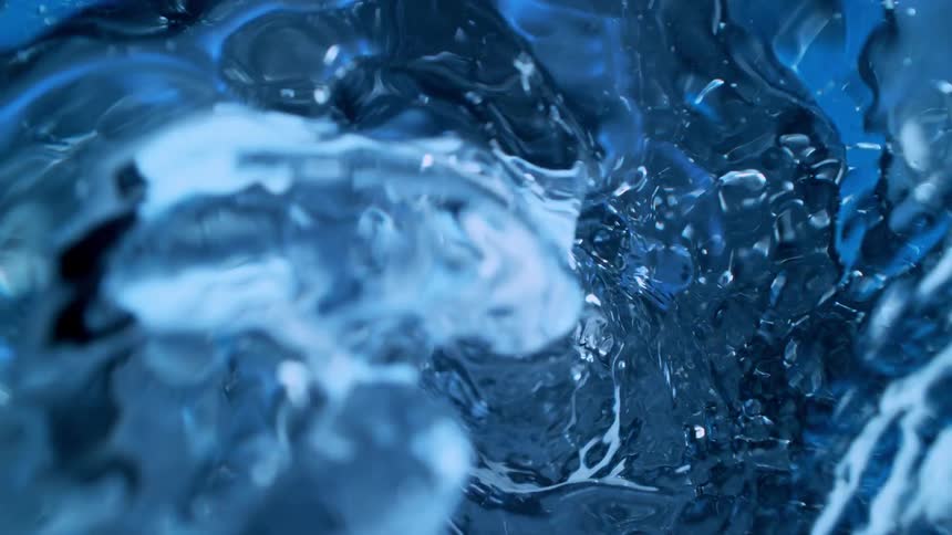 A mesmerizing super slow-motion close-up of a blue water vortex spinning into a whirlpool